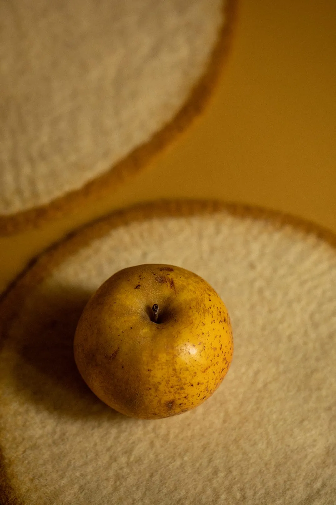 Pomme posée sur un disque de feutre jaune