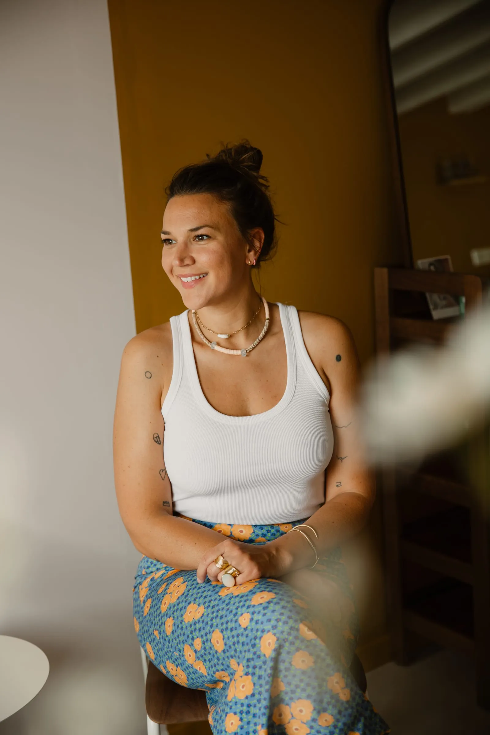 Jeanne Lozay, souriante, devant un mur ocre